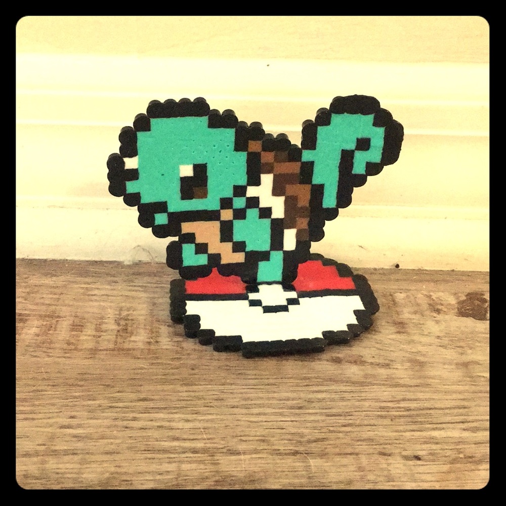 Squirtle standing on a Poké Ball.